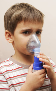 Image of young boy taking an asthma breathing treatment