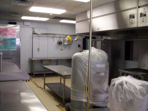 School kitchen cleaned up for summer with equipment covered with plastic
