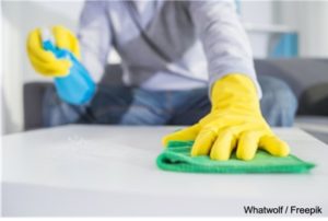 man cleaning a surface with gloves